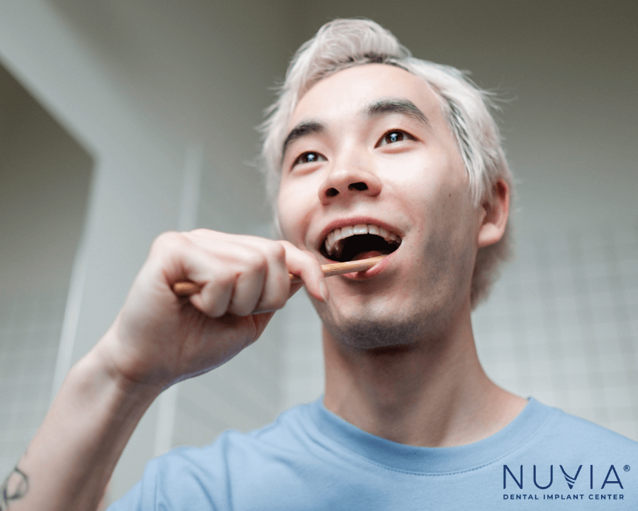 Man brushing his full mouth dental implants
