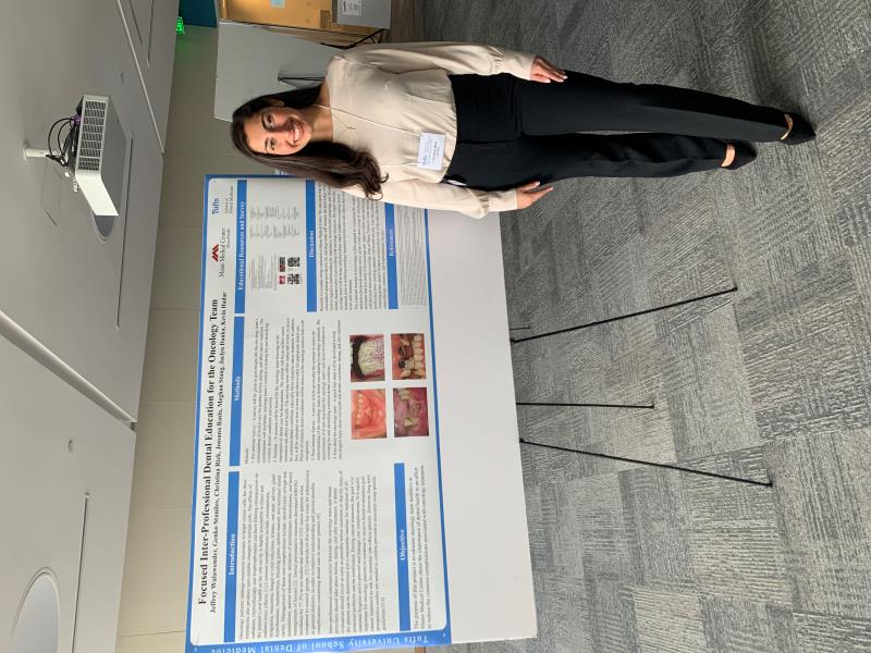 Restorative Dentist in front of presentation board