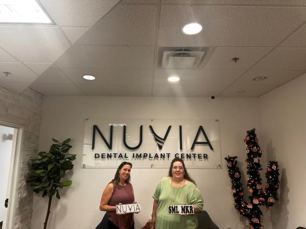 Nuvia patients with permanent teeth in one day in front of nuvia sign