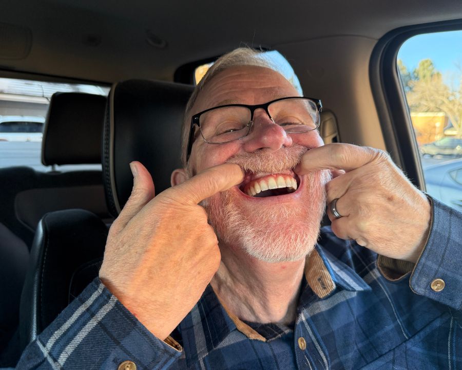 Man pulling up his top lip to show his teeth
