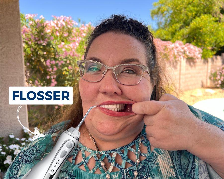Woman pulling back lip so you can see all on 4 dental implants and text that says "flosser"