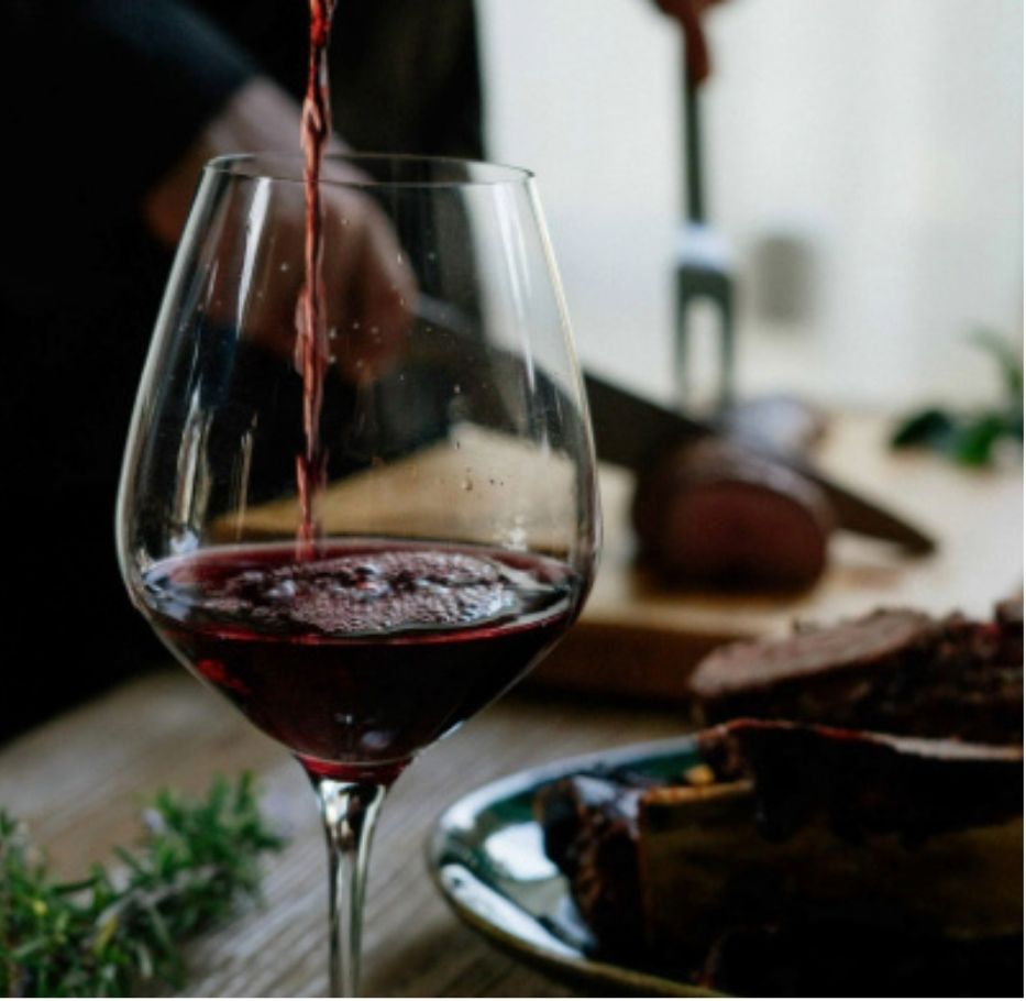 Glass of red wine being poured