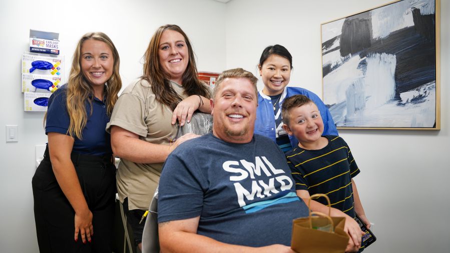 Man with a new smile taking a photo with his family