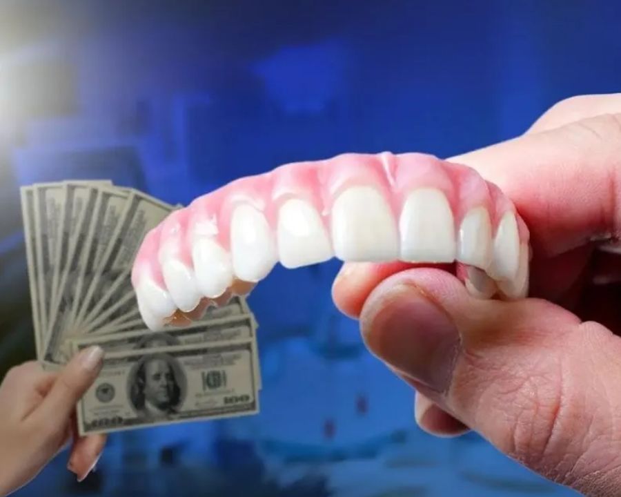 Set of zirconia teeth next to a hand holding some money