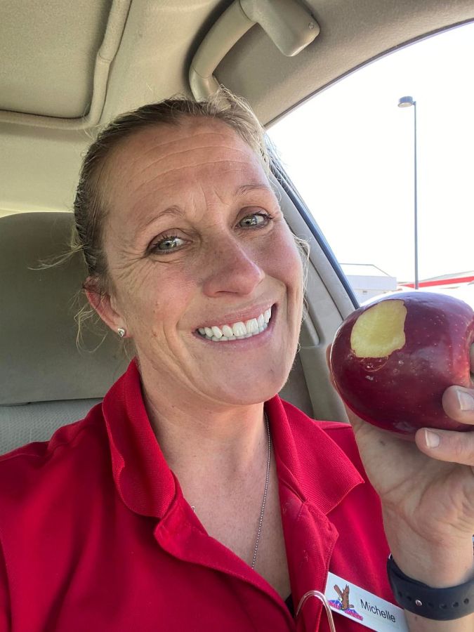 Michelle eating an apple smiling